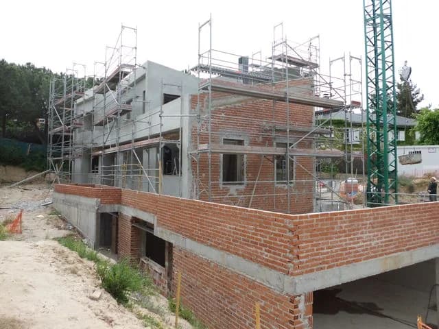 Vivienda en construcción con muros de ladrillo y andamios